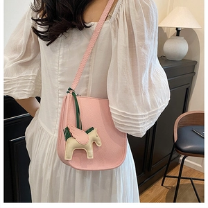 Pink lychee grain leather bucket bag with cute winged horse charm detail in luxury interior