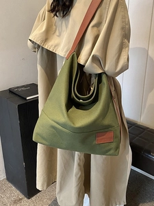 Large dark green canvas tote bag with brown straps for casual daily commuting
