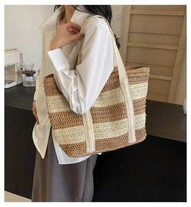 Close-up of contrast striped straw tote bag showing woven texture and shoulder strap