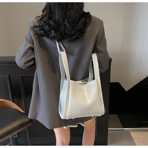 White crocodile pattern bag styled with a gray blazer for a chic commuting look