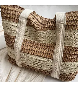 Detailed close-up of a striped straw tote bag with braided handles and zipper closure