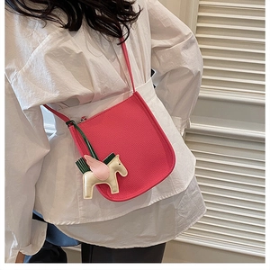 Hot pink leather bucket bag with horse charm detail and pebbled texture