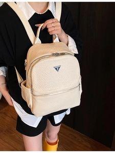 Sac à dos chic en similicuir blanc cassé avec motif texturé et logo triangulaire métallique