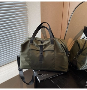 Detail of olive green nylon travel bag showing durable fabric and functional front pocket