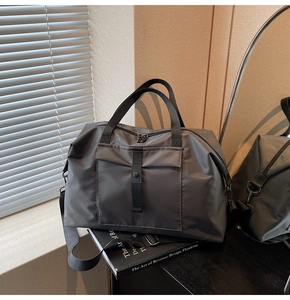 Detail of dark grey travel duffel bag with waterproof fabric and adjustable shoulder strap
