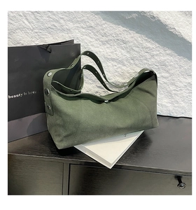 Detail of dark green suede crossbody bag featuring retro silver metal buckle and soft texture