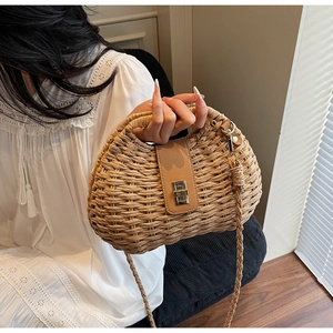 Detailed close-up of woven straw texture and premium brown leather flap with metal lock