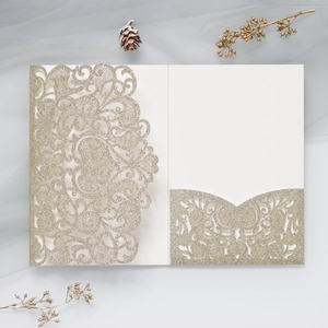 Macro detail of laser-cut wedding invitation with champagne gold glitter lace texture