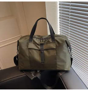 Close-up of waterproof army green travel bag with black straps on a black bench