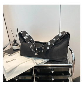 Detail of black soft shoulder bag featuring stylish silver metal studs on the strap