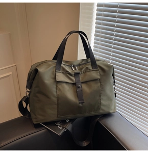 Macro detail of army green travel bag featuring nylon fabric and adjustable shoulder strap