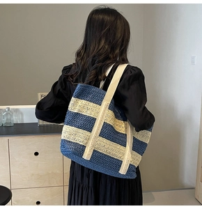 Detailed view of large capacity striped straw tote bag with woven texture and wide straps