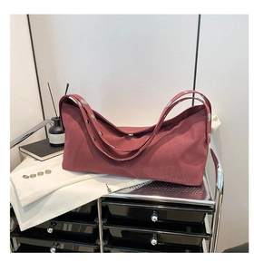 Detail of silver rivets on burgundy large tote bag shoulder strap and matte texture