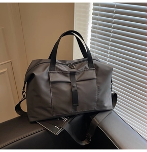 Detail of dark grey travel bag with water-repellent fabric and dual metal zippers