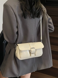 Minimalist beige glossy crossbody square bag with silver buckles and dual front pockets
