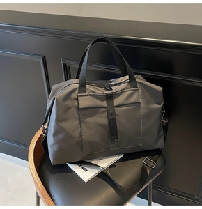 Detailed close-up of dark grey waterproof nylon travel bag with heavy duty black handles
