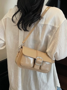Chic beige glossy crossbody bag with silver buckles and adjustable shoulder strap