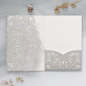 Silver glitter laser cut wedding invitation card with elegant lace pattern on tulle background