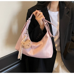 Pink underarm shoulder bag with silver hardware, plush bear charm and striped ribbon