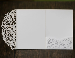 Détail du motif floral de rose blanche découpé au laser sur un faire-part de mariage