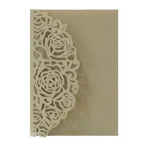 Détail macro des motifs de roses découpés au laser sur couverture d'invitation dorée