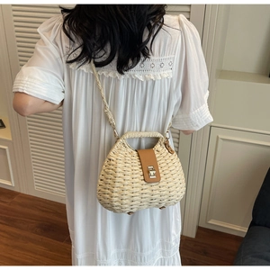 Detail of hand-woven straw crossbody bag with brown leather flap and metal lock
