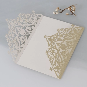 Close-up of laser-cut floral pattern on elegant ivory glitter wedding invitation