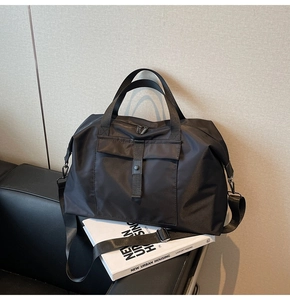 Close-up of durable black nylon travel bag featuring sturdy handles and adjustable strap