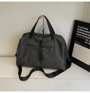 Detail of gray waterproof travel bag with reinforced handles and adjustable shoulder strap