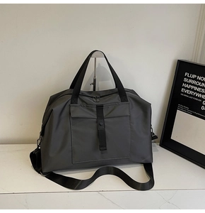Detail view of durable dark grey travel bag with buckle front pocket and wide strap