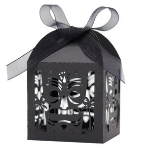 Laser-cut black gift box featuring tropical Tiki mask patterns and a black organza ribbon