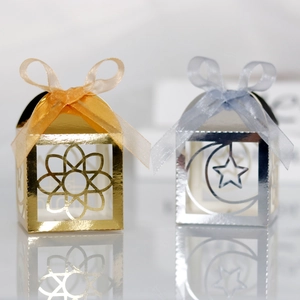 Detail of laser-cut candy boxes with star and moon patterns and organza ribbons