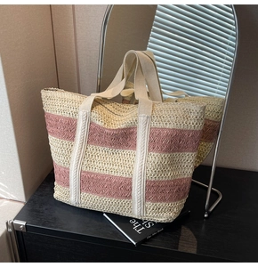 Close-up of pink and beige striped woven tote bag with durable canvas handles for beach