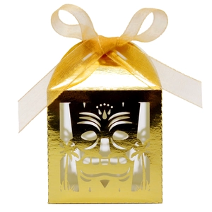 Golden laser-cut party favor box with skull mask design and matching gold ribbon