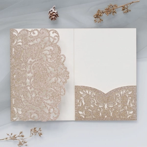 Detail of luxury champagne gold laser-cut lace wedding invitation with glitter texture