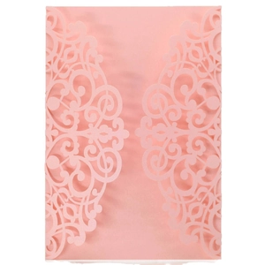 Detail of laser-cut light pink invitation cover with intricate European scroll patterns