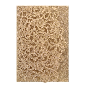 Macro detail of laser-cut gold glitter wedding invitation with intricate lace floral patterns