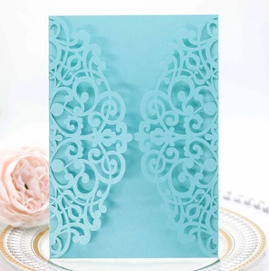 Macro detail of laser-cut invitation holder with pearl blue lace pattern on decorative plate