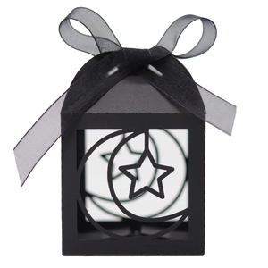 Detail of black lantern-shaped gift box with hollow moon and star patterns and ribbon