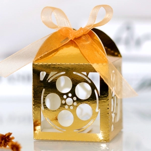 Detailed view of laser-cut film reel pattern on glossy gold gift box with ribbon