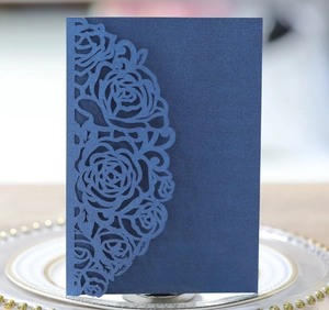 Détail de motifs de roses découpés au laser sur une carte d'invitation bleu foncé