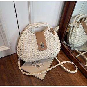 Detail of bohemian cream woven straw bag with brown leather buckle and silver twist lock