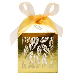 Macro detail of laser-cut gold leaf candy box with elegant organza ribbon bow