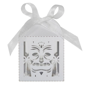 Detail of laser-cut Tiki mask and palm tree patterns on a white candy gift box