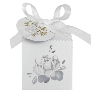 Detail of white laser-cut floral wedding favor box with silk ribbon and Thank You tag