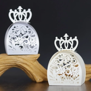 Détail macro de boîtes de mariage blanches découpées au laser avec décor de couronne