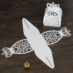 Detail of laser cut white paper gift box with cross pattern and crown top closure