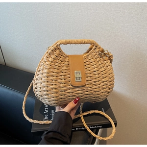 Detail of hand-woven straw bag with premium brown leather flap and golden twist lock clasp