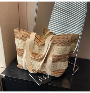 Detail of the woven texture and contrast stripes on a large capacity straw tote bag