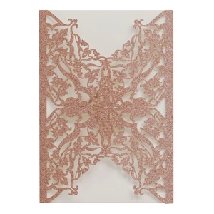 Close-up of laser-cut rose gold glitter wedding invitation with European floral patterns